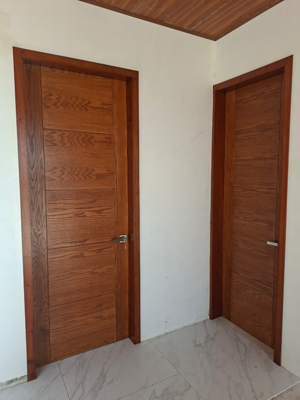 Quinta María — Puerta entamborada en triplay de encino de 6 mm con marcos y vistas en madera natural sólida de cedro